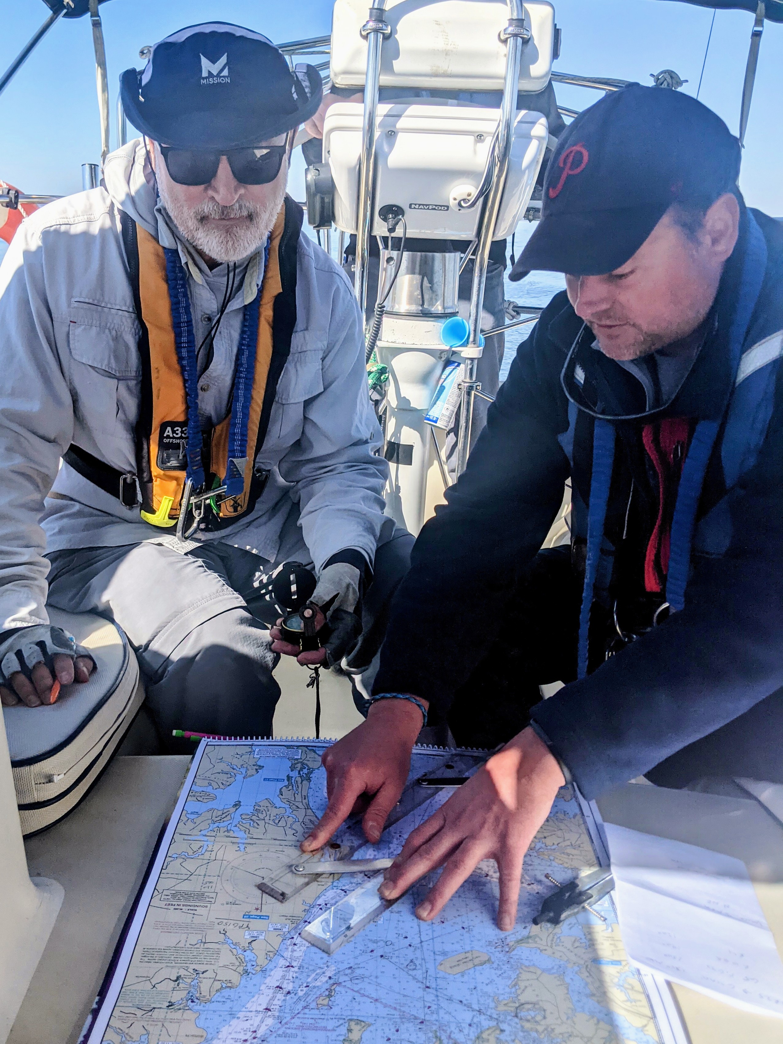 Four sailors belowdecks consulting a chart as the Captain indicates their position