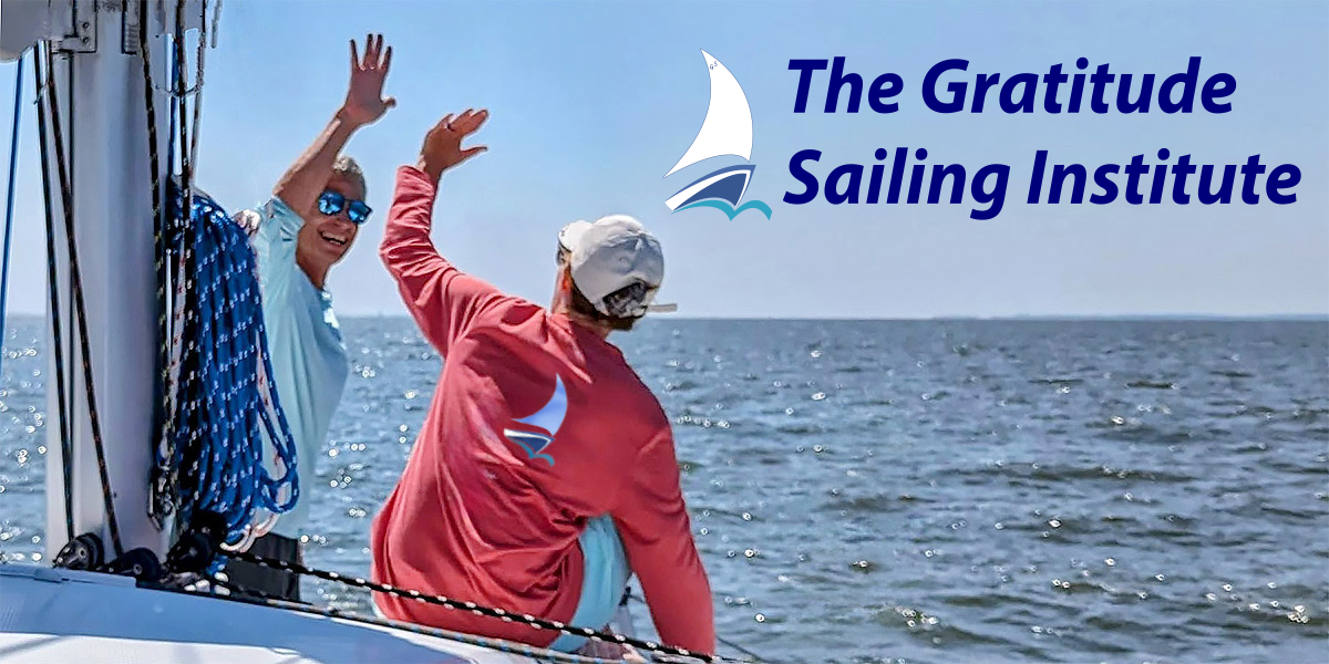 Two sailors sharing a high five while sailing on the Chesapeake Bay
