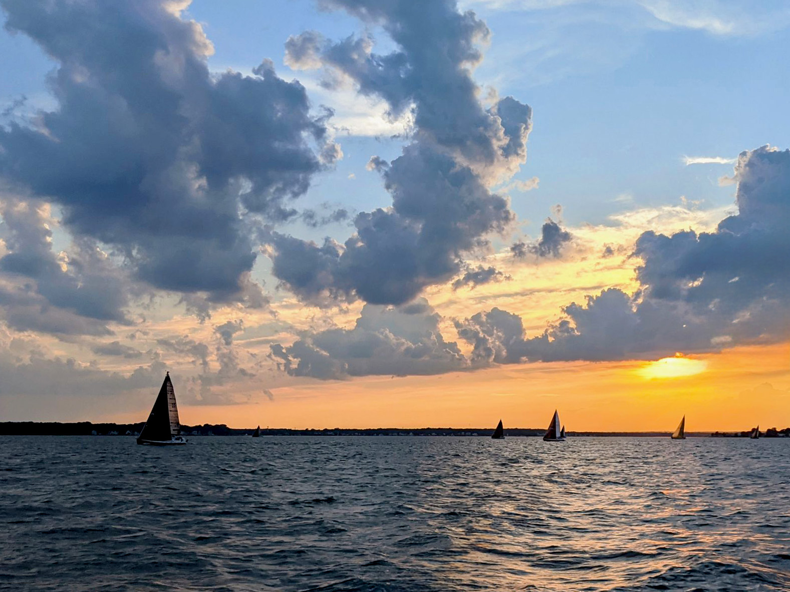 Sailboats on the water during a colorful sunset